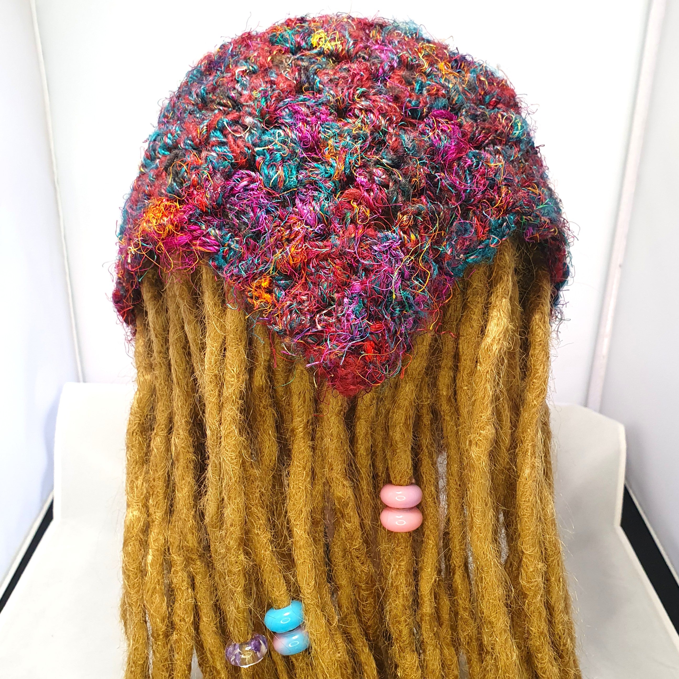 Multicolour sari silk crochet loc bandana worn over golden dreadlocks, shown from behind